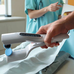 Handheld white reflex stimulator held in use with blue pad attachment