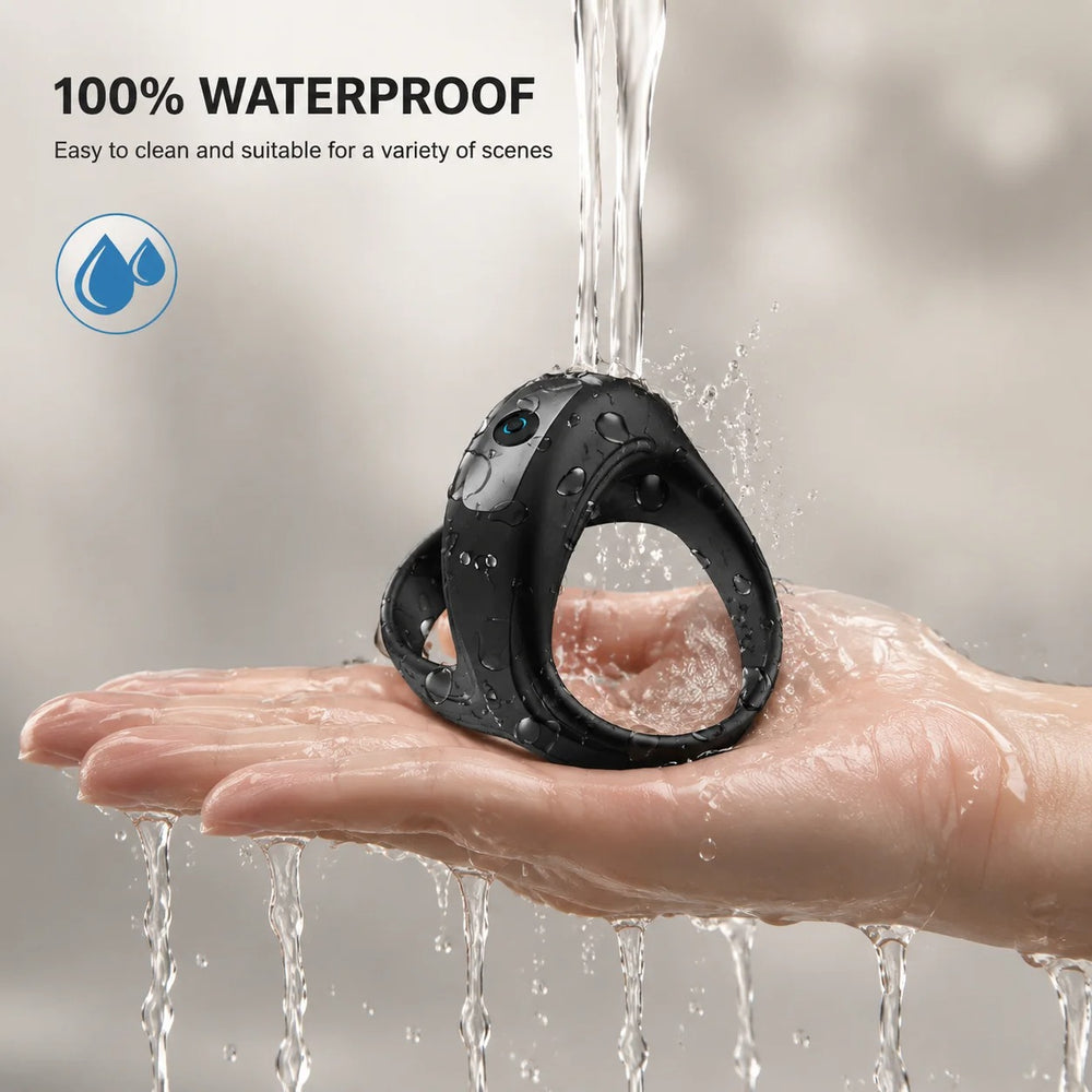 Waterproof black silicone ring massager with blue lens on a wet hand